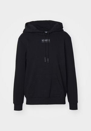 Sudadera negra de tejido suave, con un bolsillo canguro central, cordones y una etiqueta rectangular en el pecho.