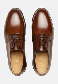 Braune Leder-Oxfords mit glatter Oberfläche, runder Zehenform und fünf Ösen-Schnürung. Das Innere weist ein geprägtes Markenlogo auf.