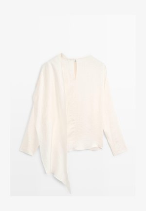 Blusa leggera di colore crema a maniche lunghe con tessuto testurizzato, schiena scoperta e dettaglio a occhiello nel scollo.