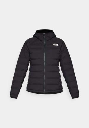 Chaqueta acolchada negra con capucha, con cremallera frontal, bolsillos laterales y un logotipo en el lado izquierdo del pecho. Fabricada con un tejido ligero y texturizado.