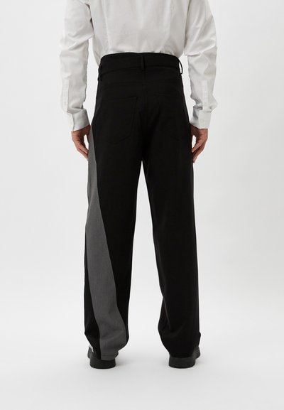 Schwarze Hosen mit einem kontrastierenden grauen Einsatz am linken Bein, gerades Bein Design und sichtbare Gesäßtaschen.