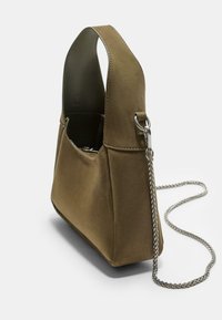 Brun suedetasker med en struktureret form, en kort hank og en aftagelig kædelestraps. Har slanke syninger og en glat overflade.