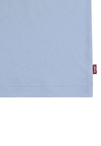Tela de algodón azul claro con dobladillo recto y una pequeña etiqueta roja que muestra el logo blanco de Levi's en el lado derecho.