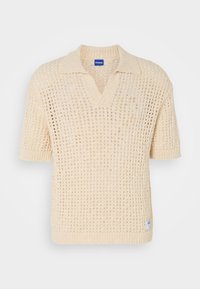Kortermet polo genser i lys beige, laget av et åpenstrikket, teksturert stoff med V-hals og ribbestrikkede ermer og hem. HUGO-logo merkelapp inkludert.