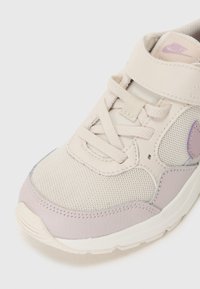 Botte de sport beige en matériaux mesh et cuir, avec un accent violet, des lacets et une sangle en velcro. Bout arrondi et surface texturée.