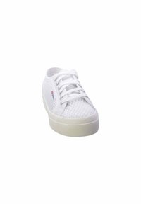 Sneaker bianco in rete con punta arrotondata, chiusura con lacci e suola in gomma testurizzata. Presenta un piccolo logo sul lato. Design leggero.