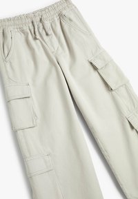 Lys beige cargo bukser lavet af blødt stof. Har en elastisk talje, flere store sidelommer og quiltede detaljer.