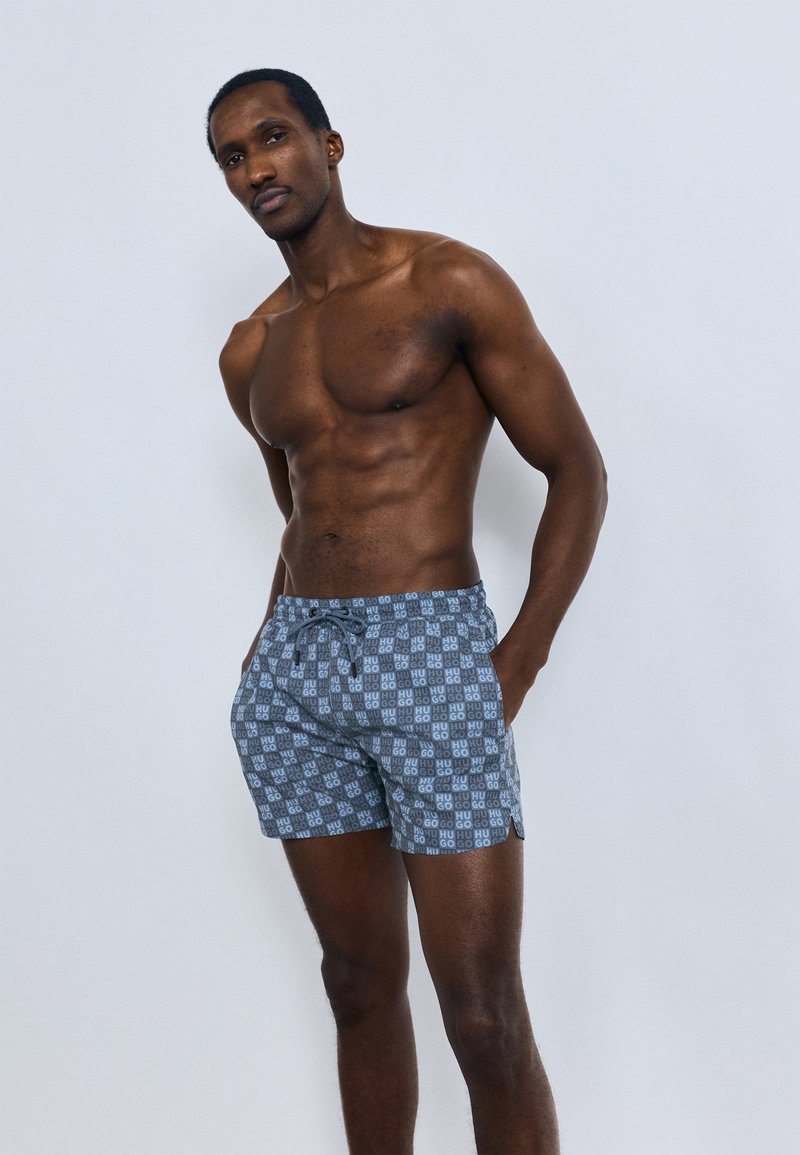 Heren zwemshorts met een blauw-grijs geometrisch patroon, voorzien van een elastische tailleband met trekkoord en zijzakken.