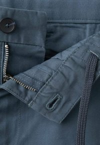 Close-up of dark blue pants waistband showing a button, partially unzipped zipper, buttonhole, and braided drawstring.