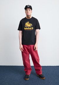 Timberland FRONT BOOT GRAPHIC TEE - Apdrukāts T-krekls - black