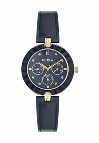 Furla sat s kružnim tamnoplavim brojčanikom, zlatnim akcentima, tri podbrojčanika i tamnoplavom kožnom narukvicom s zlatnim hardverom i šavovima.