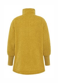 Polaire à enfiler couleur jaune moutarde, dotée d'un col montant, d'épaules tombantes et de poignets en côtes. Matière douce et texturée avec une coupe décontractée.