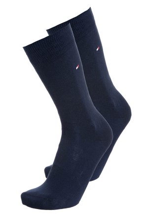 Marineblaue Baumwollsocken mit gerippten Bündchen und einem kleinen Logo mit roten und weißen Akzenten. Standard-Röhrenschnitt mit glattem Material.