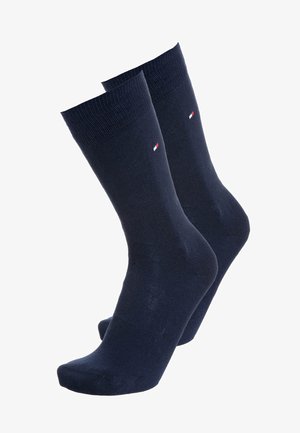 Navy blue cotton socks with ribbed cuffs and a small logo featuring red and white accents. Standard tube shape with a smooth texture.