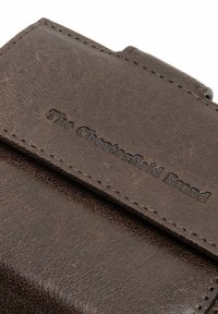 Brown textured leather wallet featuring a smooth flap closure and embossed brand name. Stitched edges and minimal hardware details.
