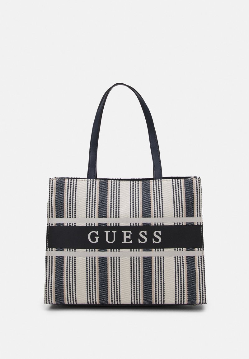 Tygväska i beige och marinblått med randigt mönster, slät tyg och svart logoband. Inkluderar två stadiga handtag för bärning.