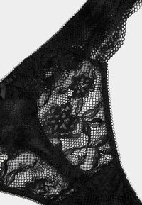 Schwarze Spitzenunterwäsche mit floralen Mustern, Netzeinsatz und zarter Kante. Inklusive Satinschleifen an den Seiten für zusätzliche Details.