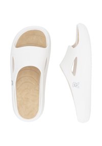 Des sandales blanches à enfiler avec un extérieur en plastique lisse et une semelle intérieure beige douce. Elles présentent des côtés découpés et une semelle texturée pour une meilleure adhérence.