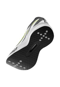 Baskets noir et blanc avec une semelle en caoutchouc texturée présentant des motifs circulaires, un dessus lisse avec des rayures diagonales et un accent vert fluo.