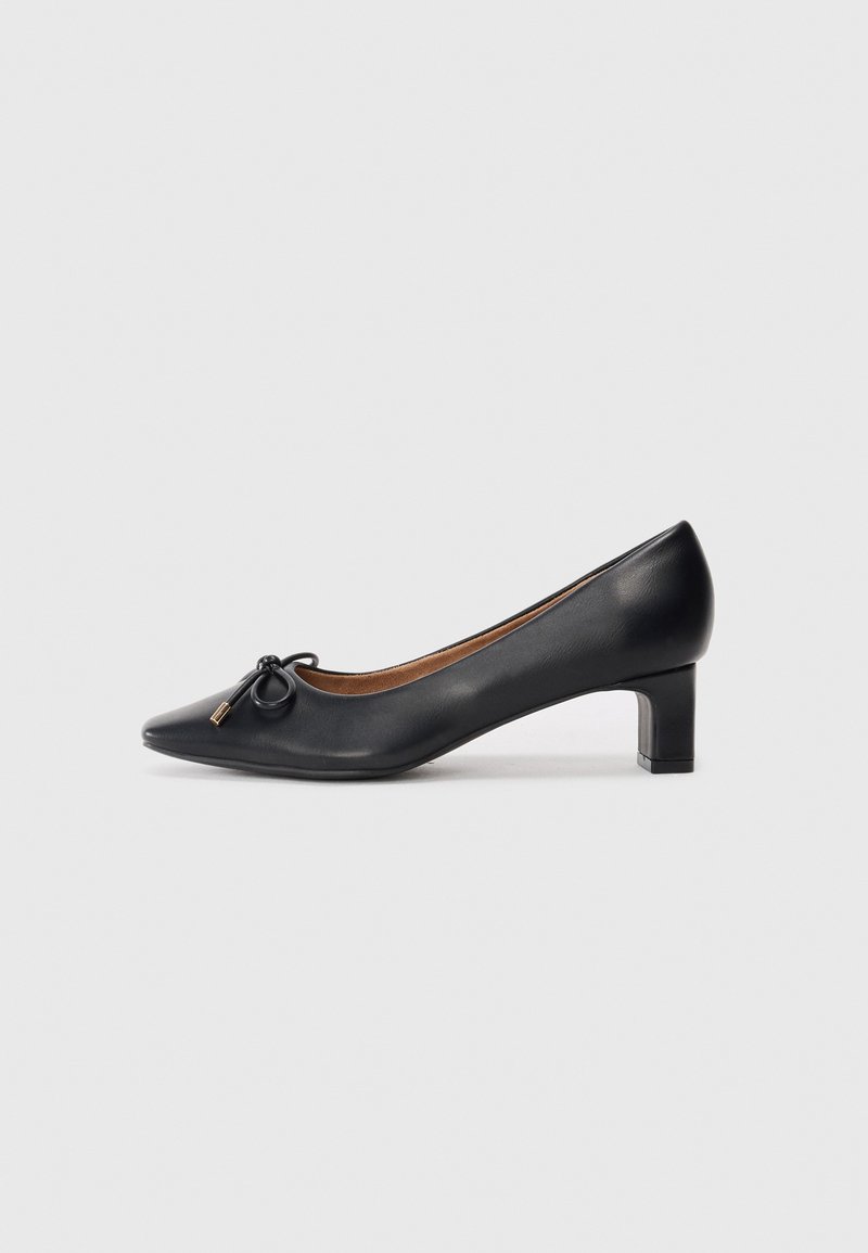 Black leather pump with a pointed toe, small heel, and decorative bow detail on the front. Smooth texture and simple design.