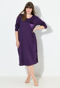 Lila långärmad klänning med en satinficka, lös passform och sidoklipp för lättare rörelse. Mjukt, lätt material.
