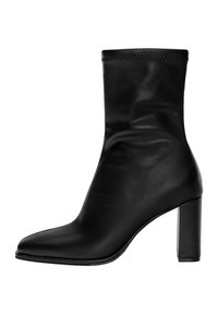 Bottine en cuir noir avec une coupe ajustée, un bout pointu, un talon bloc haut et un détail de couture subtil sur le bord supérieur.