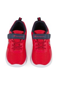 Chaussures de sport rouges avec une tige en tricot texturé, une sangle bleu marine et une semelle blanche. Les caractéristiques incluent des lacets et un détail de logo sur la sangle.