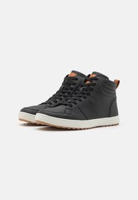 Black high-top sneakers made of smooth leather, featuring a white rubber sole, brown heel tab, and black laces. Subtle side panel design.