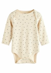 Body à manches longues crème avec un motif à pois noirs, présentant un col rond et des boutons-pression en bas. Matière en coton douce.