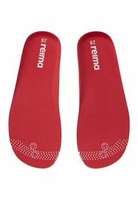 Para czerwonych wkładek Reima w rozmiarze 28 z białym logo i wzorem kropkowanego uśmiechniętego facecika w pobliżu palców na białym tle.