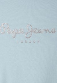 Šviesiai mėlyna džemperis su sidabriniu blizgučiu tekstu "Pepe Jeans LONDON" kursyvine šriftu per krūtinę. Minkšta, lygi audinio tekstūra.