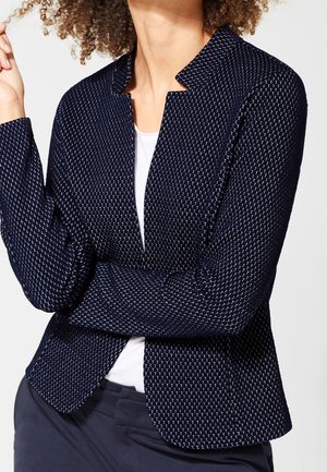 Marinblå strukturerad kavaj med geometriskt mönster, avslappnad passform, öppen framsida och långa ärmar. Har en insnittad krage och slät foder.