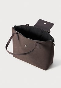 Brun toteveske i syntetisk materiale, med glidelås og flate stropper. Innvendig er den svart og har en liten klafflomme med trykknapp.