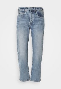 Jasnoniebieskie dżinsy, tapered z prostą nogawką, pięć kieszeni, z przodu zapięcie na guzik i zamek, wyblakła faktura z subtelnym przyciemnieniem.