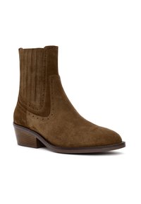 Brown suede ankle boot with low stacked heel, elastic side panel, and decorative perforated trim.
