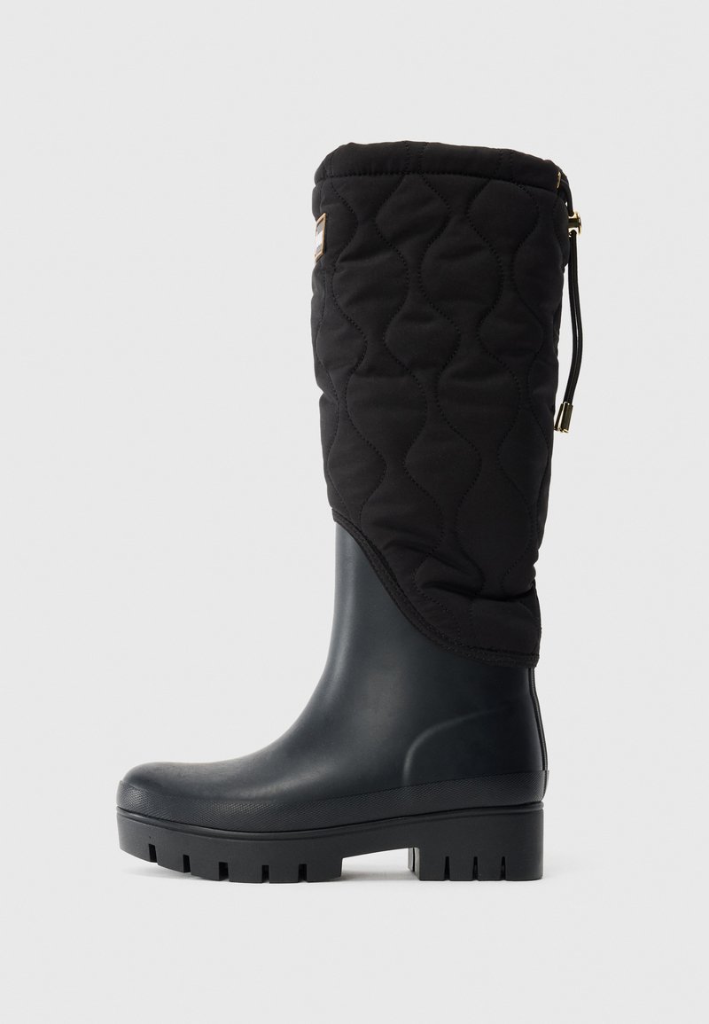 Botte noire imperméable avec tige en tissu matelassé, semelle à crampons épaisse et sangle réglable en haut, conçue pour le temps froid et humide.