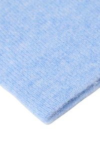 Lichtblauwe textiel met een zachte, fuzzy textuur, met een glad oppervlak en een licht geweven uitstraling, met een omgevouwen rand.