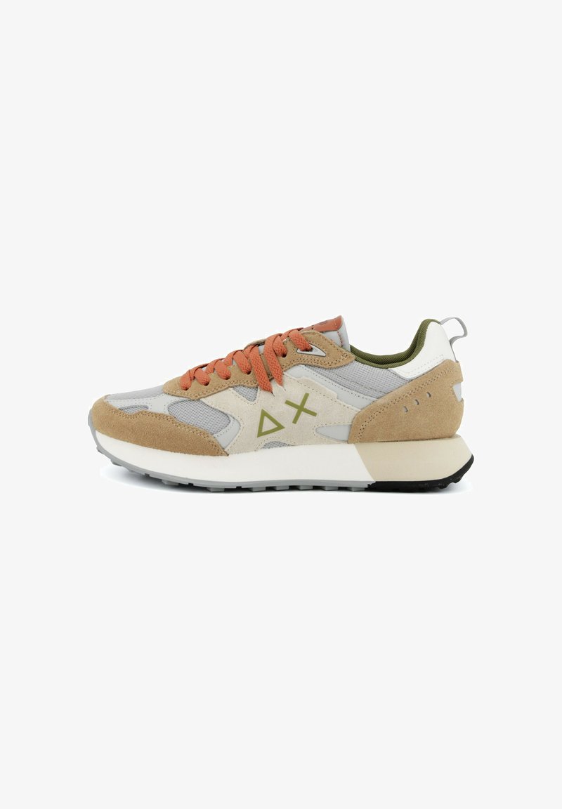 Baskets beige, grises et blanches avec des lacets orange, une doublure intérieure vert olive, des détails en daim et des symboles géométriques sur le côté.