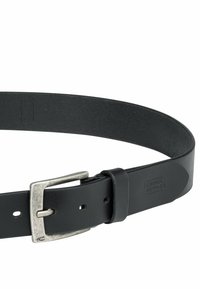 Sort læderbælte med en sølvmetallås. Glat tekstur, enkelt design, justerbart med flere huller, mærket med "camel active."