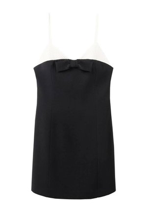 Zwart-wit topje met dunne bandjes, met een geribbelde witte bovenkant en een zwarte onderkant, versierd met een strikje in het midden.