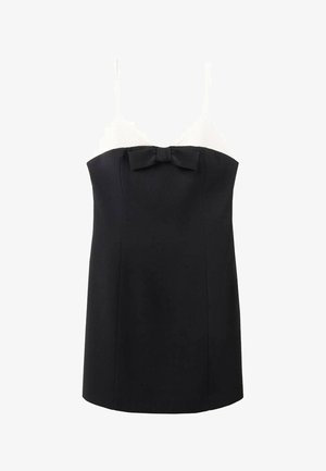 Camisón en blanco y negro con tirantes finos, que presenta una parte superior texturizada blanca y una parte inferior negra, acentuada con un lazo en el centro.