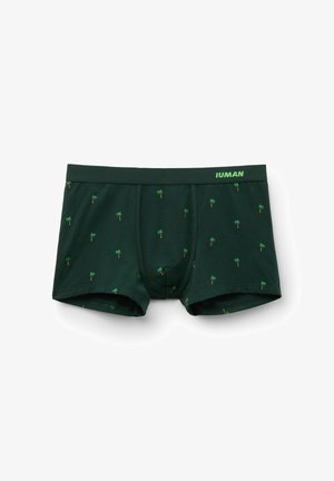Ciemnozielone męskie bokserki z małym wzorem palm i markowym pasem z napisem "IUMAN" w jasnej zieleni na białym tle.