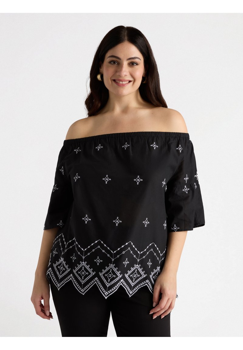 Top negro sin mangas con off-the-shoulder que presenta patrones geométricos bordados en blanco y un dobladillo con forma de ola, confeccionado en una tela ligera y texturada.
