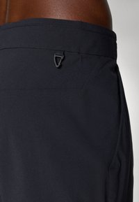 Shorts navy en tissu léger avec une texture lisse, dotés d'un petit détail en métal noir à la taille et d'une surpiqûre des poches.
