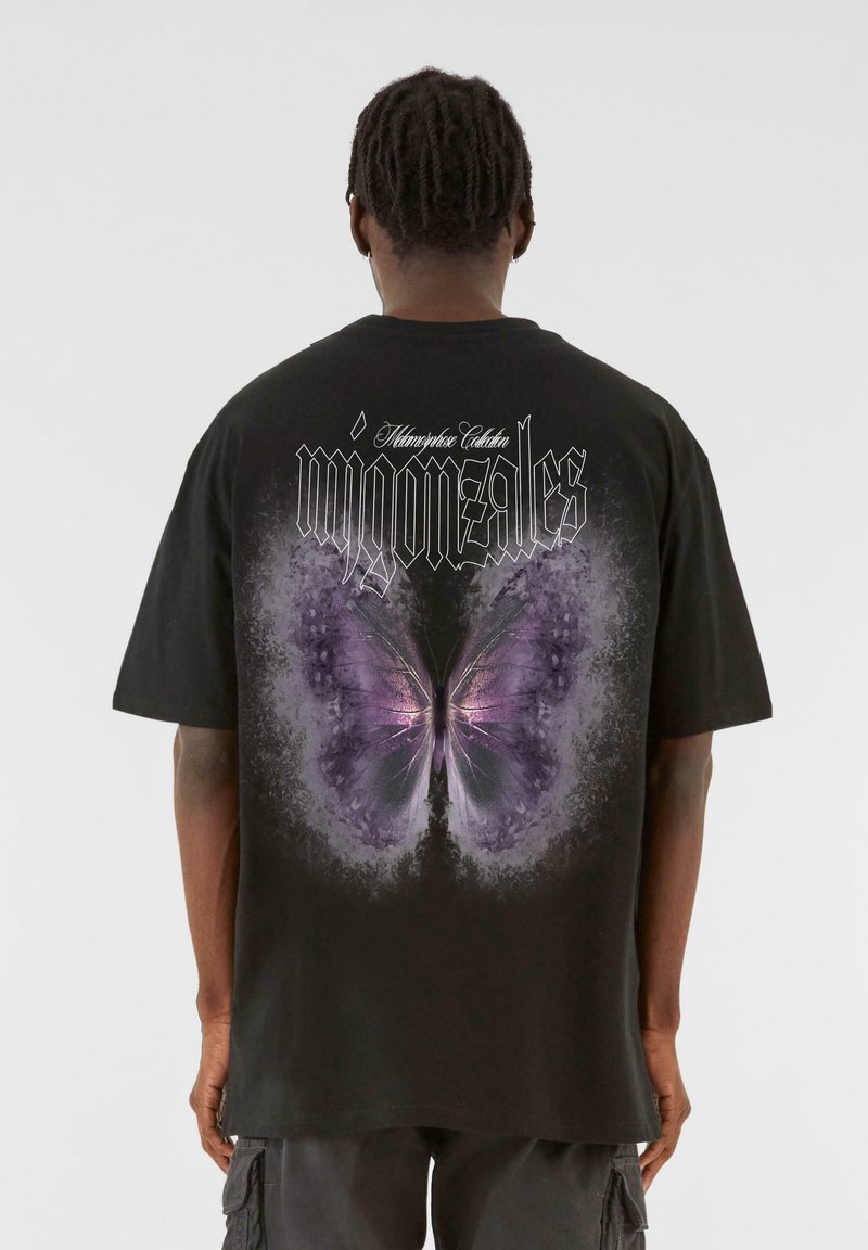 Black oversized t-shirt featuring a large purple butterfly graphic on the back, with stylized text above and an abstract design surrounding the butterfly.