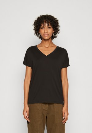 Black V-neck t-shirt with short sleeves, made from soft fabric. Simple design without patterns or accents. Worn with cargo pants.
