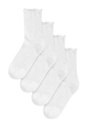 Quatre paires de chaussettes blanches, propres, longueur moyenne, disposées en pile légèrement décalée sur un fond blanc.