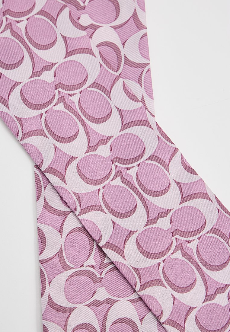 Textil mit einem sich wiederholenden Muster aus überlappenden ovalen Formen in hellrosa und dunkleren Rosatönen, mit einer strukturierten Stoffoberfläche.