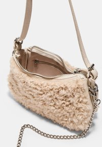 Borsa a tracolla in finta pelliccia beige con un'esterno testurizzato, tracolla in catena argentata e una tasca interna con zip. Fodera liscia e chiusura con zip.