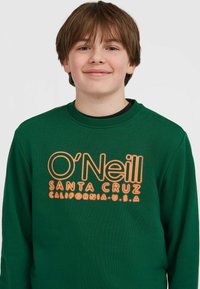 Zelená mikina s okrúhlym výstrihom, na prednej strane s oranžovým textom "O'Neill SANTA CRUZ CALIFORNIA U.S.A.".